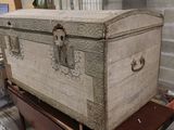 an old trunk sitting on top of a cart in a room