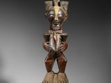 une image représentant une statue en bois d'une femme portant une couronne sur la tête