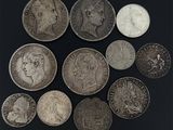 six types différents de pièces d'argent sur une surface noire