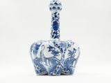 an old blue and white vase with a bird on it ' s neck