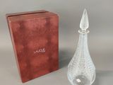 an image of a glass perfume bottle next to a red box