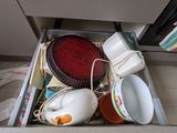 a drawer full of dishes and cups in a kitchen