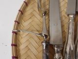 a basket with silverware and a knife on top of it