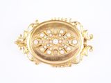 une image représentant une broche en or ornée de perles sur fond blanc