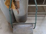 a metal bucket with a handle and a bag on it
