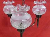 three glass lamps hanging from a chain on a red background