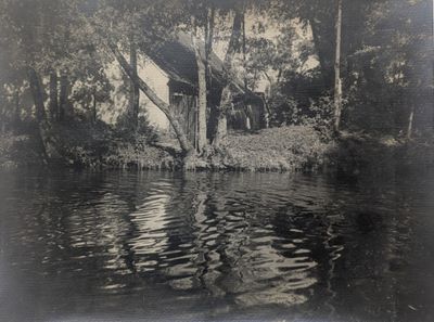 une photo en noir et blanc d'une maison au bord de l'eau