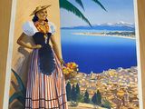 affiche représentant une femme en costume traditionnel debout devant un paysage marin