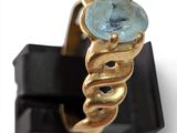 a gold ring with a blue topaz stone on it