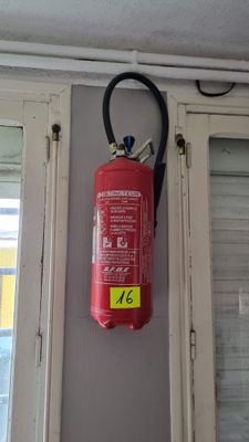 a red fire extinguisor hanging on the wall