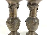 two metal vases sitting on top of each other