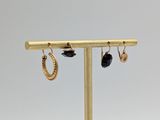 a close up of a pair of earrings on a stand