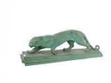 statue d'un chat posée sur un socle en bois, sur fond blanc