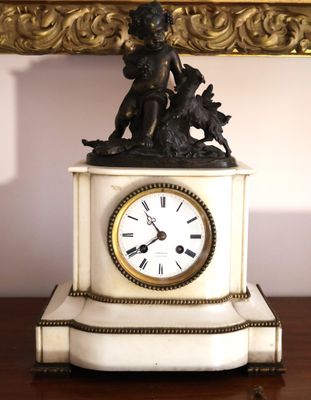 une horloge surmontée d'une statue, posée sur une table