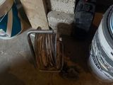 une photo représentant un seau de peinture et un tuyau d'arrosage dans un garage