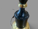 a black and gold lamp that is on top of a table