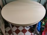 une table au plateau blanc posée sur un sol à carreaux rouges et blancs