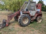 un tracteur rouge garé dans l'herbe