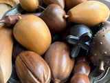 a bowl full of wooden fruit on a table
