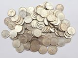 une pile de pièces d'argent posée sur une surface blanche