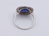 a close up of a ring with a blue stone in it
