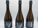 trois bouteilles de vin posées l'une à côté de l'autre sur une table