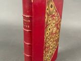 an old red book with a gold design on the cover