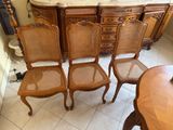 several chairs and a table in a room next to a dresser