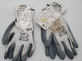 two pairs of gray and black work gloves on a white surface