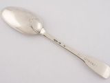 silver spoon with writing on it on a white surface