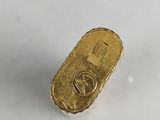 a close up of a small gold object on a white surface