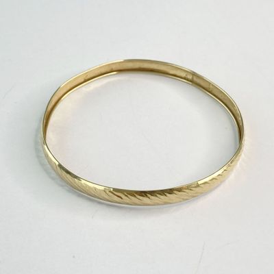 une image d'un gros plan d'une bague en or sur une surface blanche