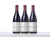 three bottles of red wine are lined up on a table