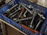 a pile of screws in a blue basket on a table