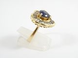 a close up of a gold ring with a blue stone