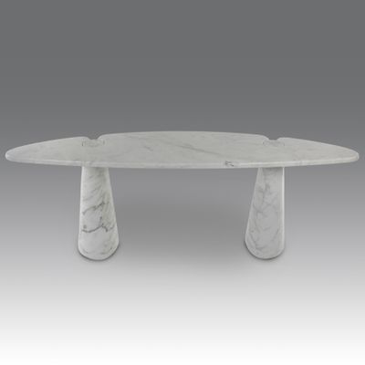 an oval marble dining table with three legs and a white marble top