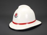 a white fireman ' s hat with a red stripe around the brim