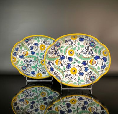 two plates with flowers on them sitting on a table