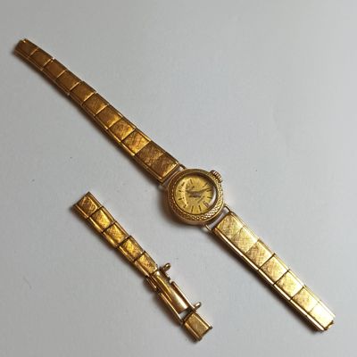 an image of a gold watch and a gold bracelet on a white surface