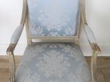 blue and white upholstered chair in a room with wood floors