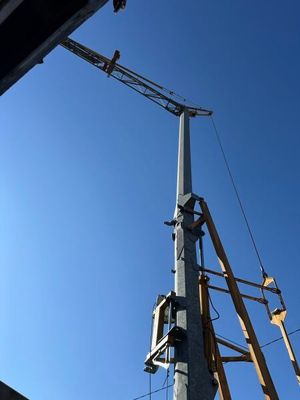 a crane that is standing next to a power pole