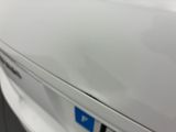 the door handle of a white car with a blue sticker on it