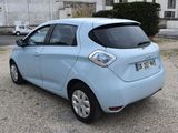 a picture of a small blue car parked in front of a building