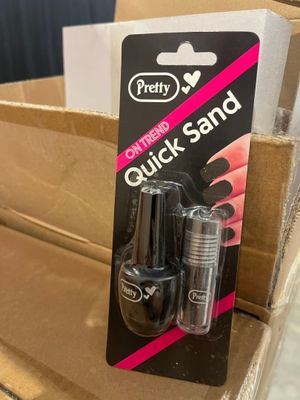 une boîte contenant deux flacons de vernis à ongles posée sur une boîte en carton