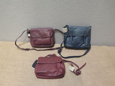 trois sacs de couleurs différentes posés les uns à côté des autres sur une table