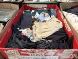 une boîte remplie de vêtements posée par terre