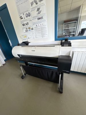 a large printer sitting on a stand in a room