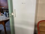 a white refrigerator in the corner of a room