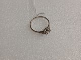 un gros plan d'une bague en argent posée sur un tissu blanc