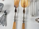 a lot of silverware on a table with spoons and forks